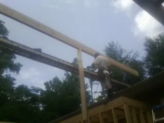 Carpenter setting a ridge beam over a new addition frame — Ice Dam Removal by Roofing Brothers in Waynesville