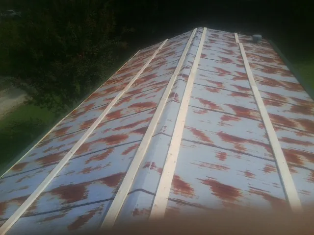 Rusted metal roof panels with new wood purlins before replacement — Storm Damage Roof Repair in Waynesville by Roofing Brothers