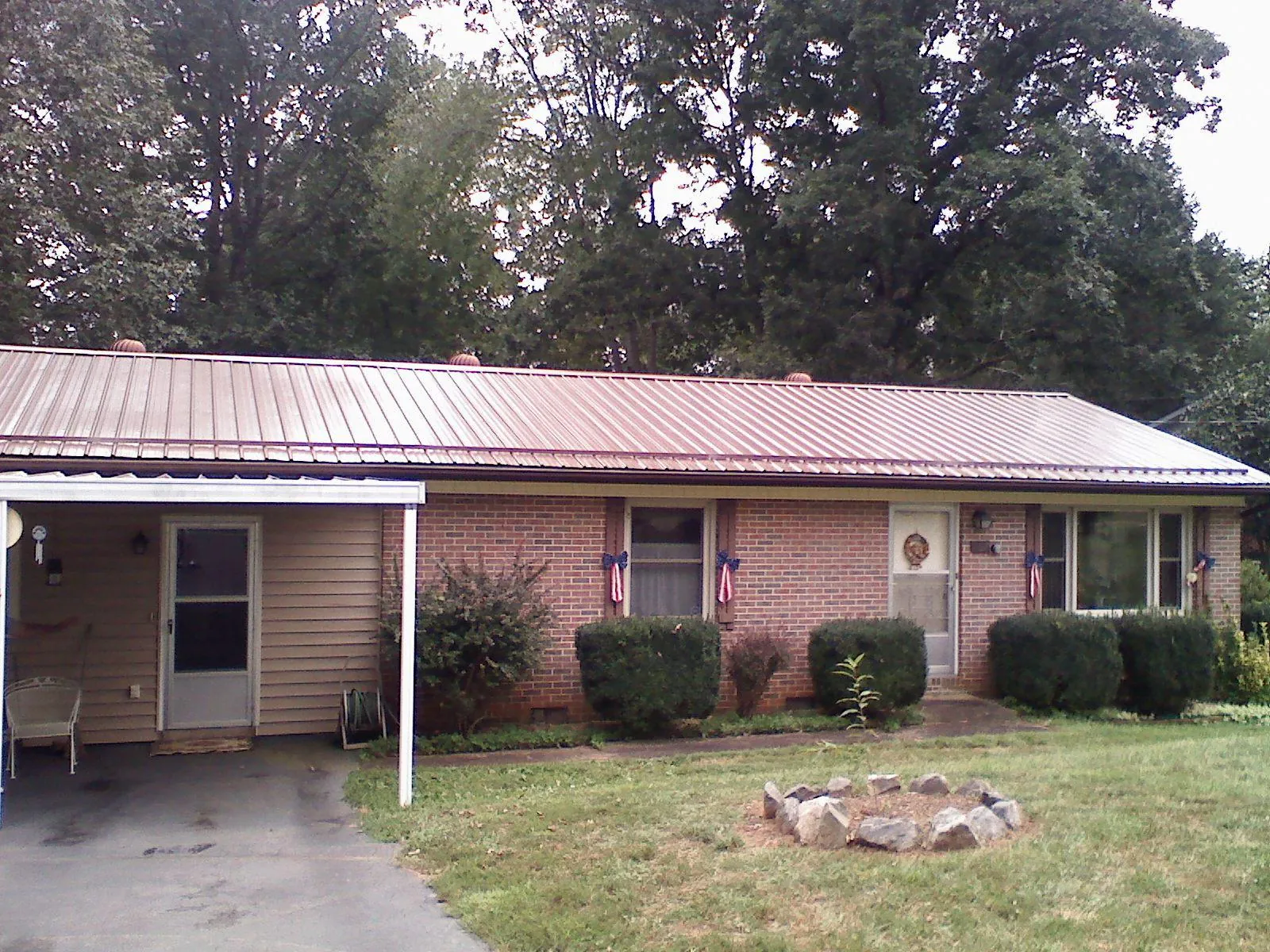 Bronze metal roof and carport on a brick ranch home — Roof Repair work by our crew in Waynesville